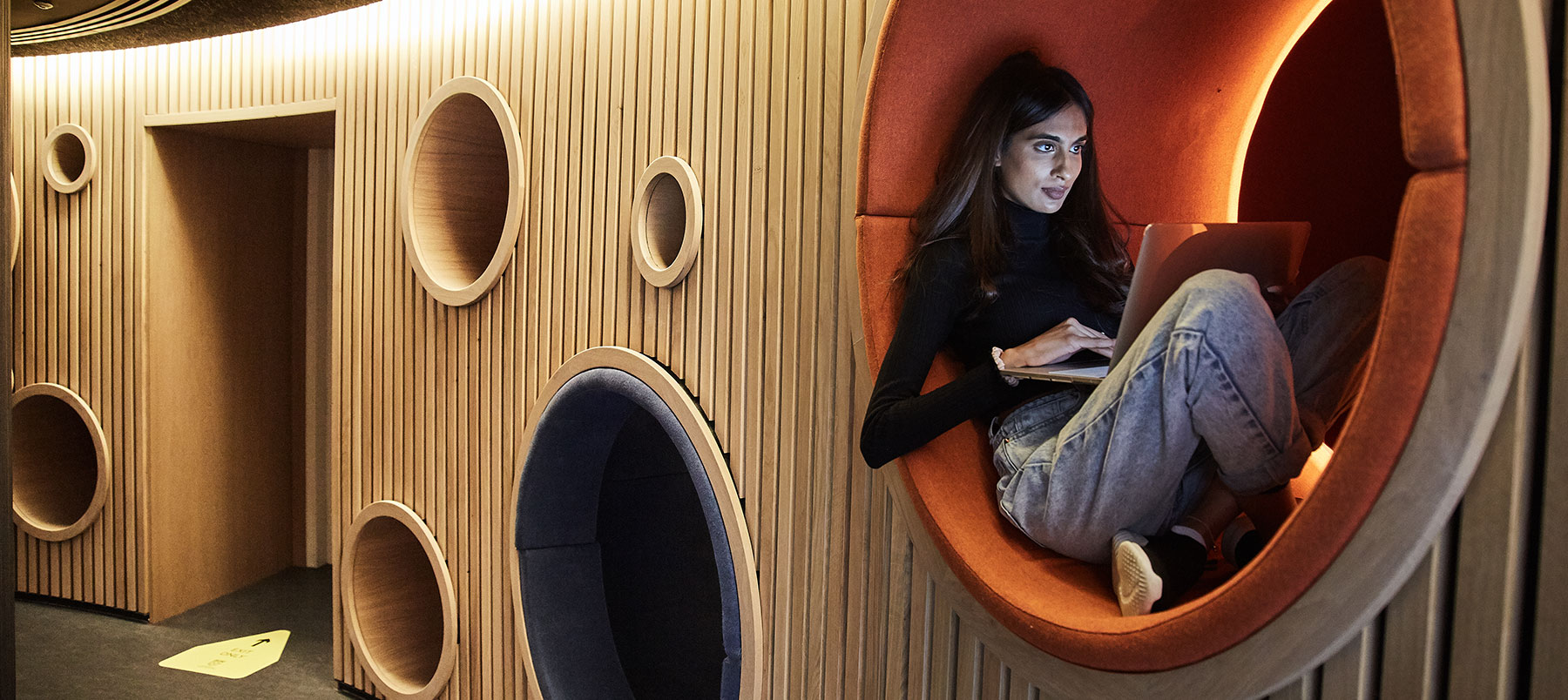 Student sitting inside a whole in the wall in our Contemplation Space