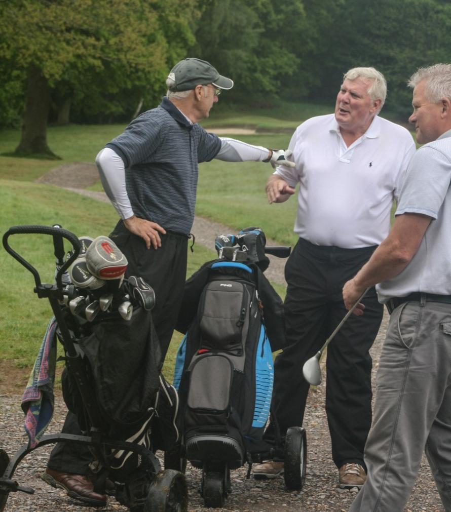 Alumni laughing on golf course