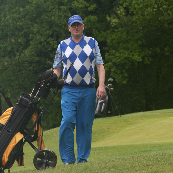 Alumni with golf bags stood on golf course