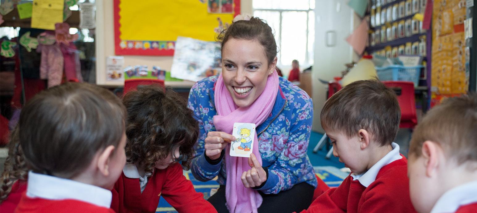 Teacher showing a card to a group of children