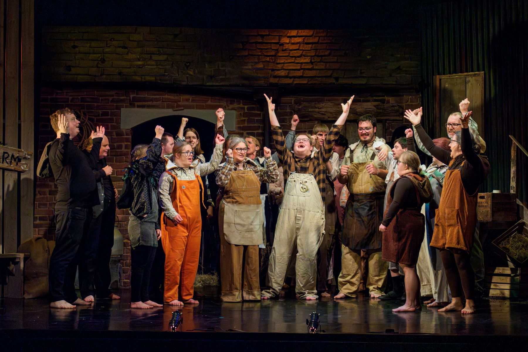 Lots of people on theatre stage waiving their arms in the air