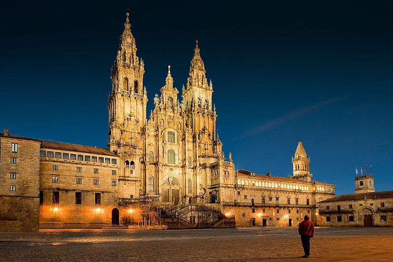 large cathedral lit up against dark blue night sky