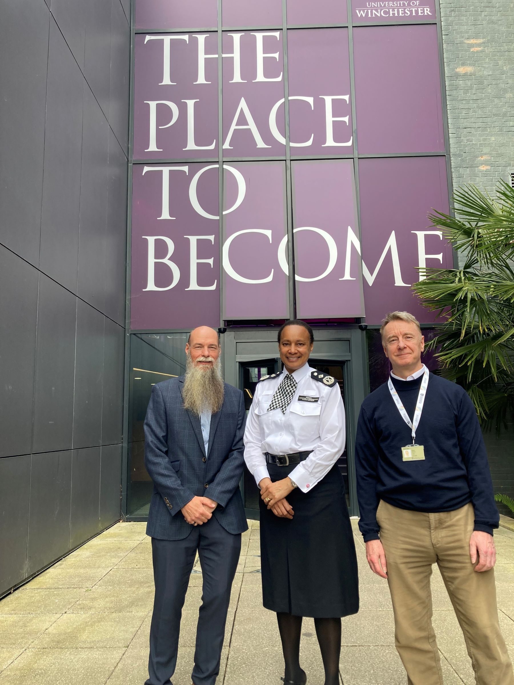 Female police officer flanked by two men