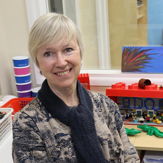 Alison James seated in front of table of Lego models