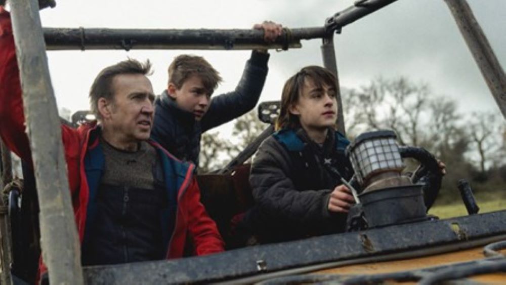 Still from movie Arcadia. Man and two teenage boys in open top vehicle