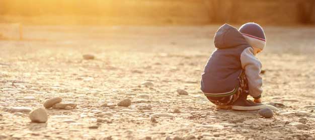 Child playing alone on a sandy beach