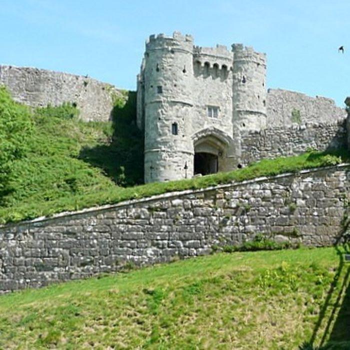 Woman standing in front of old stone walls and gateway