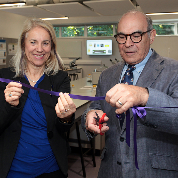 David Suchet cutting a purple ribbon in the forensics lab