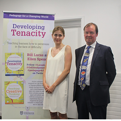 Man and woman standing in front of promotional stand