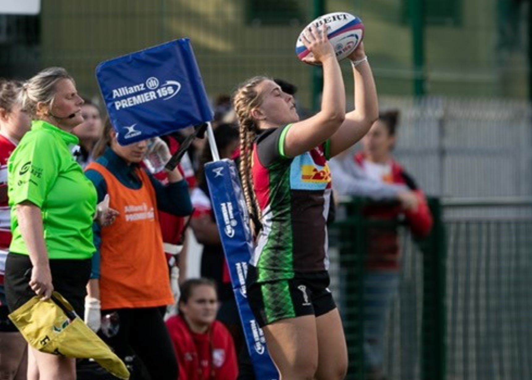 Girl rugby player with ball in hand throwing in at lineout