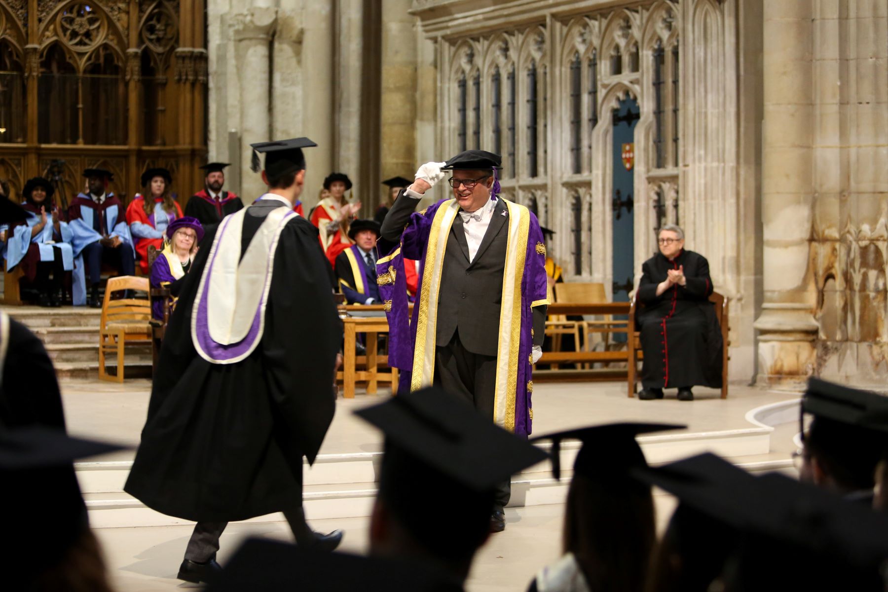 Graduate and Pro Chancellor doffing cap