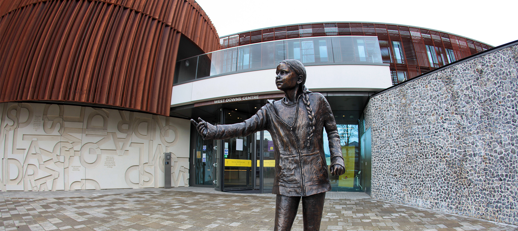 Greta Thunberg bronze statue in front of building