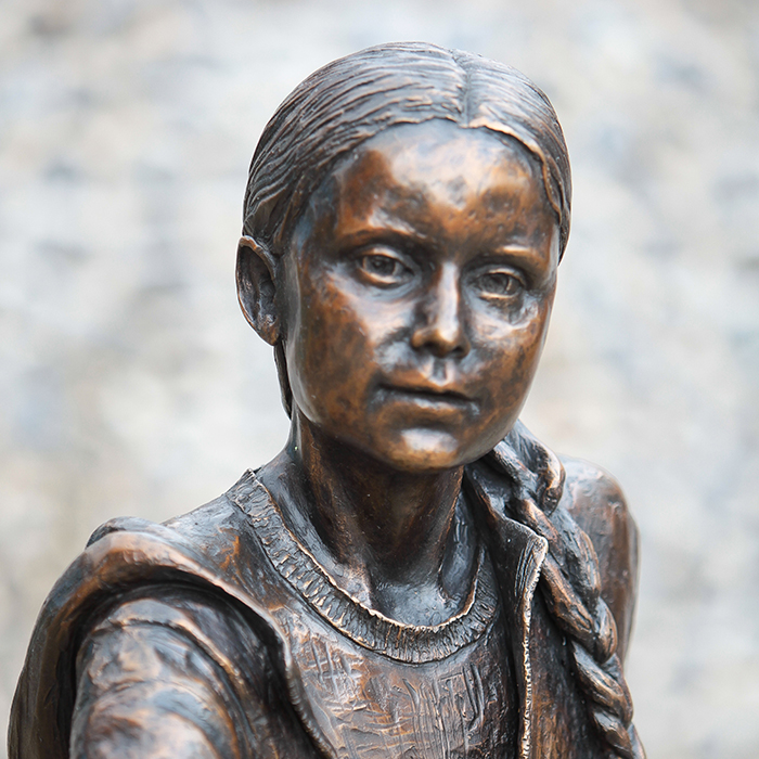 Greta Thunberg bronze statue in front of building
