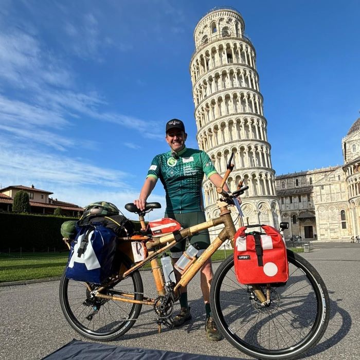 Cyclist in front of leaning Tower of Pisa