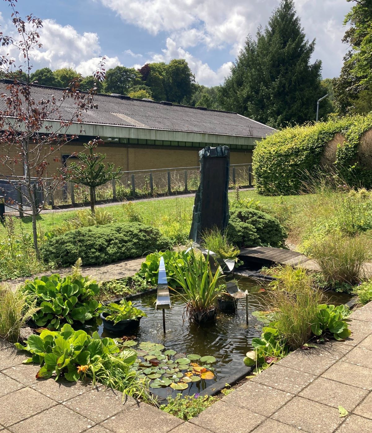Small ornamental pond with stone sculpture in centre