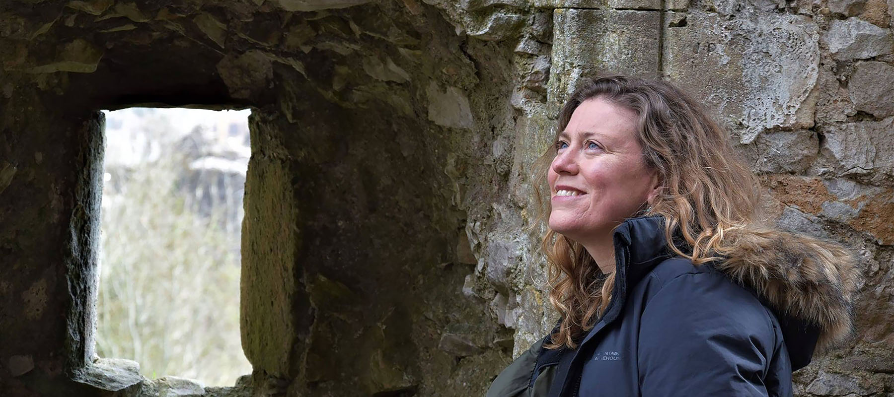 Kate Weikert standing next to medieval building ruins