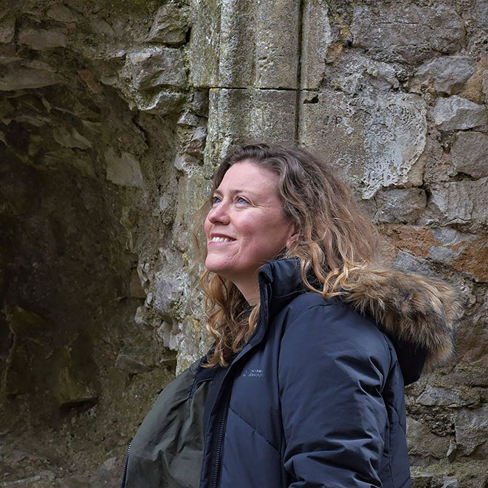 Kate Weikert standing next to medieval building ruins