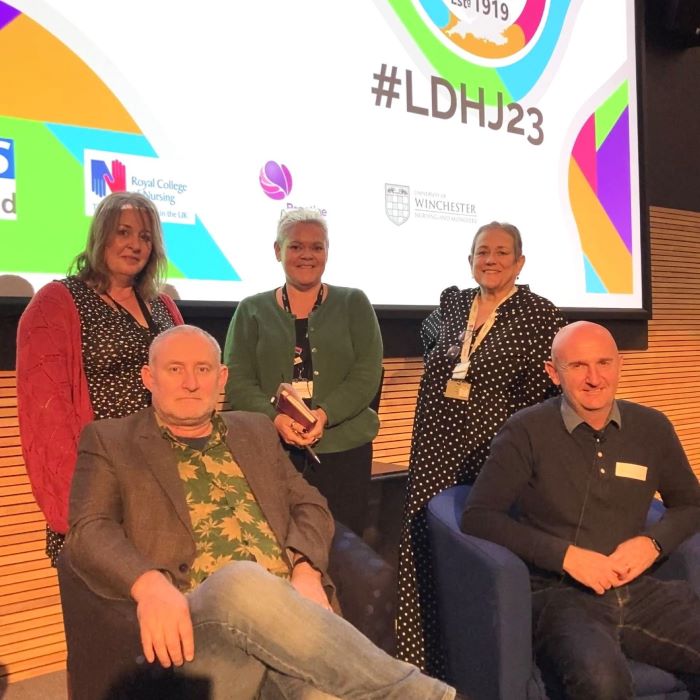 Group of people in front of a large screen at conference