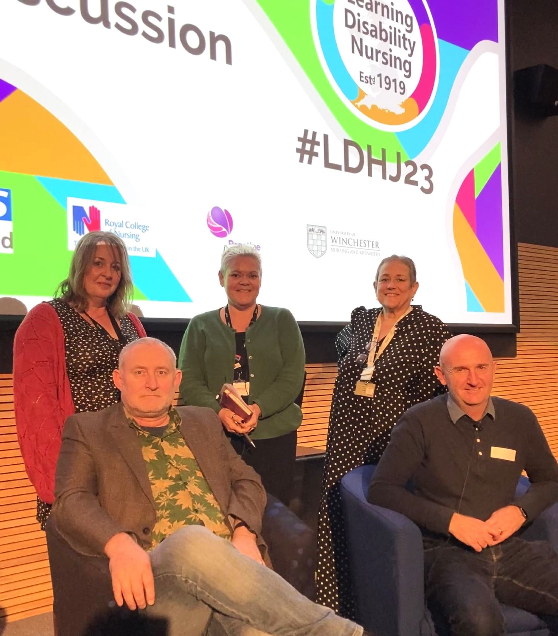 Group of people in front of a large screen at conference