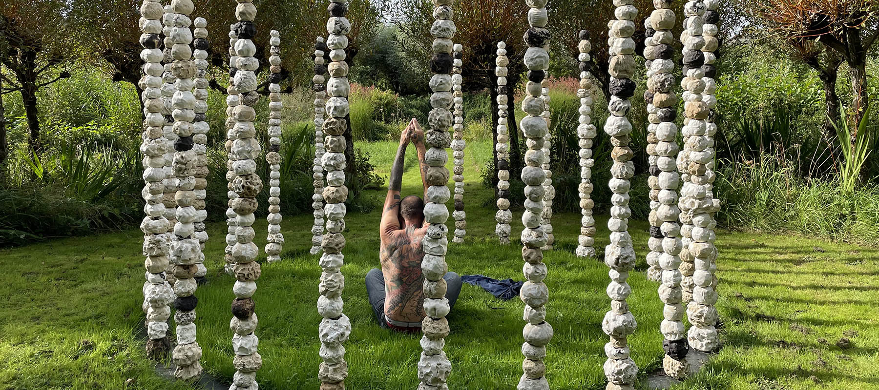 Man sitting inside circle of stomes