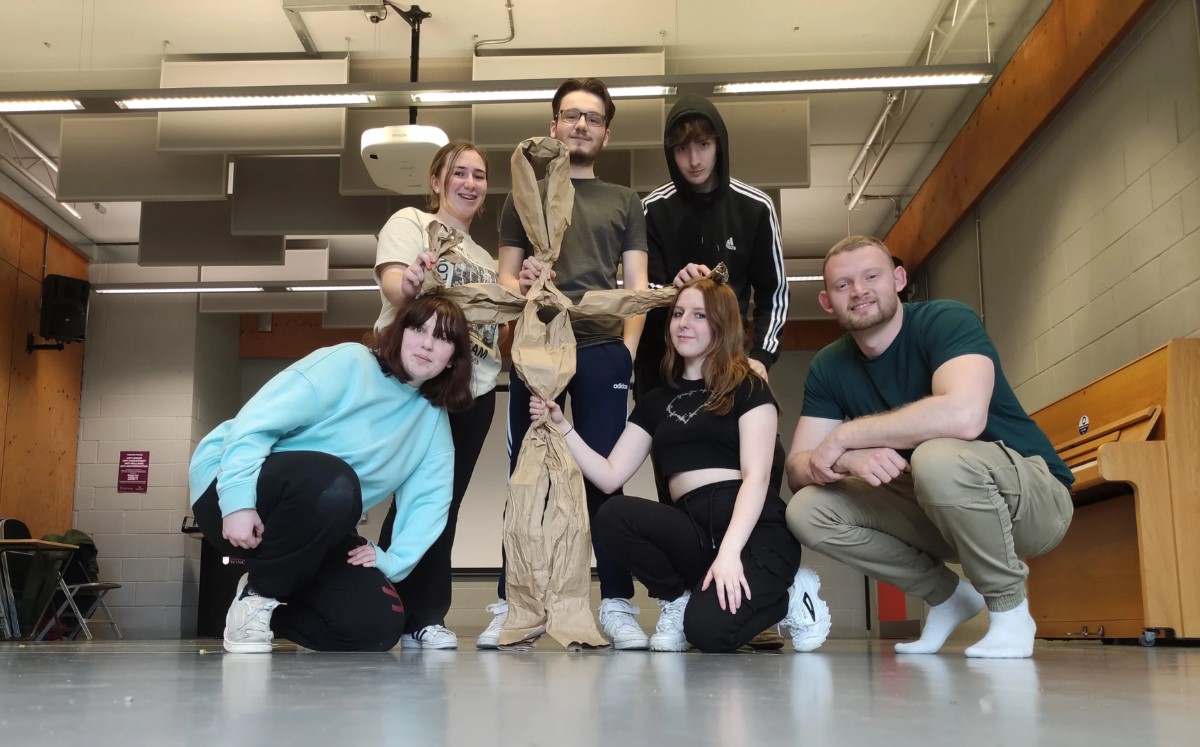 Group of young people with a puppet made from twisted paper