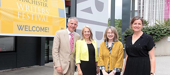 Four people standing together outside a building