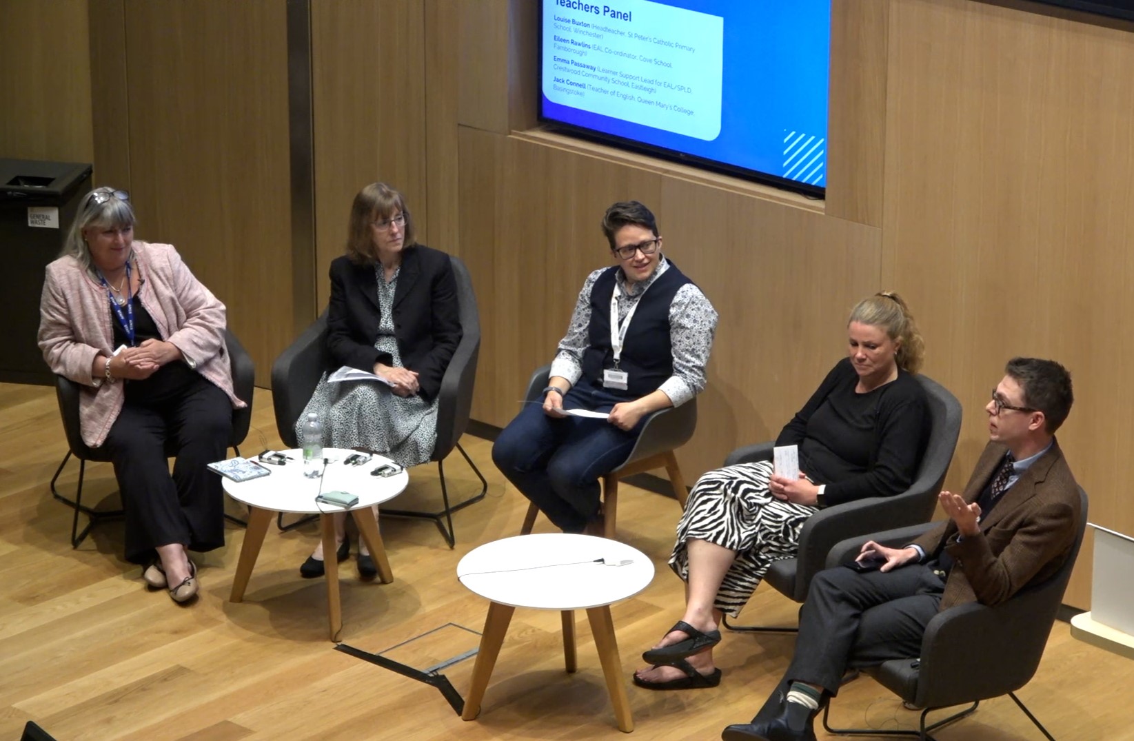 Five people sitting in semi circle in front of screen