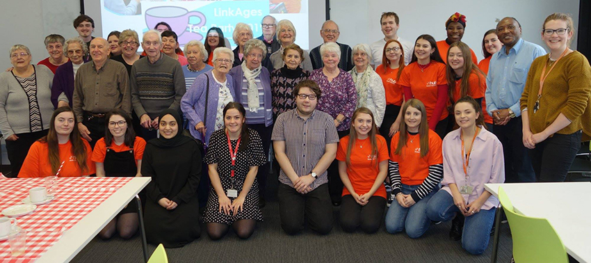 Group of student volunteers pose in orange t shirts