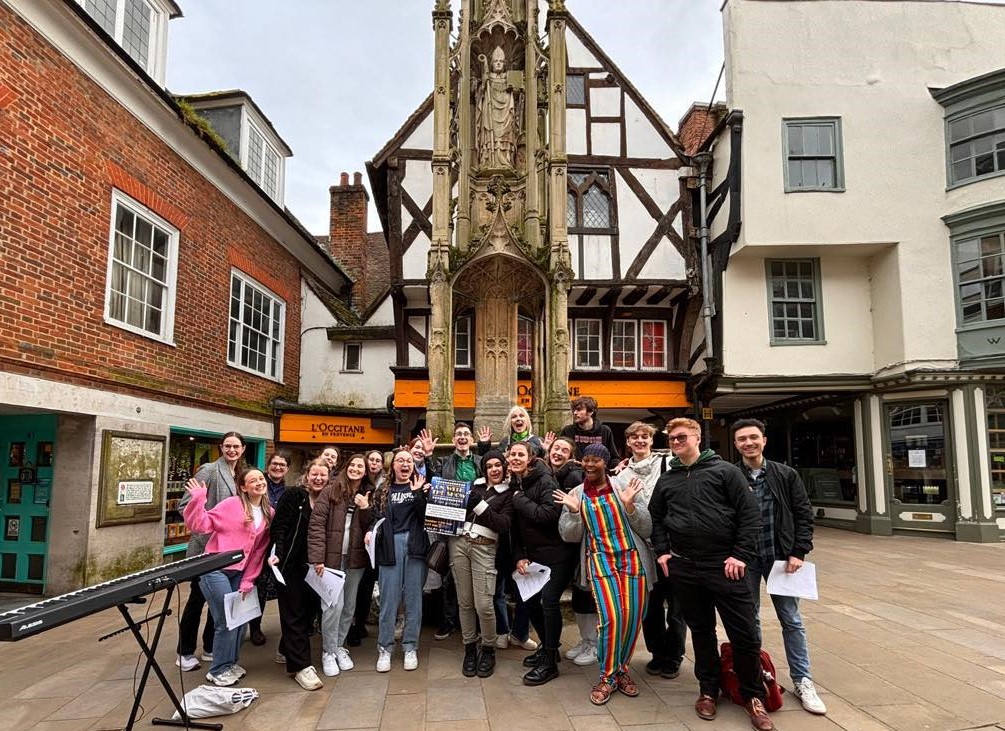 Young singers in a group by old buildings in city centre pedestrian precinct