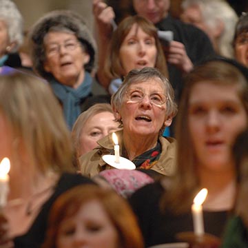 Congregation singing with some holding lighted candles