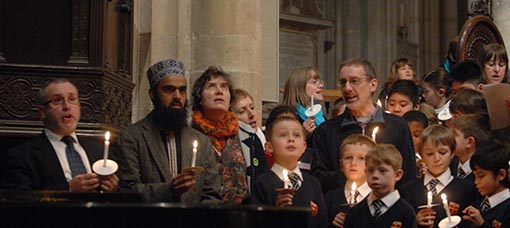 Congregation singing with some holding lighted candles