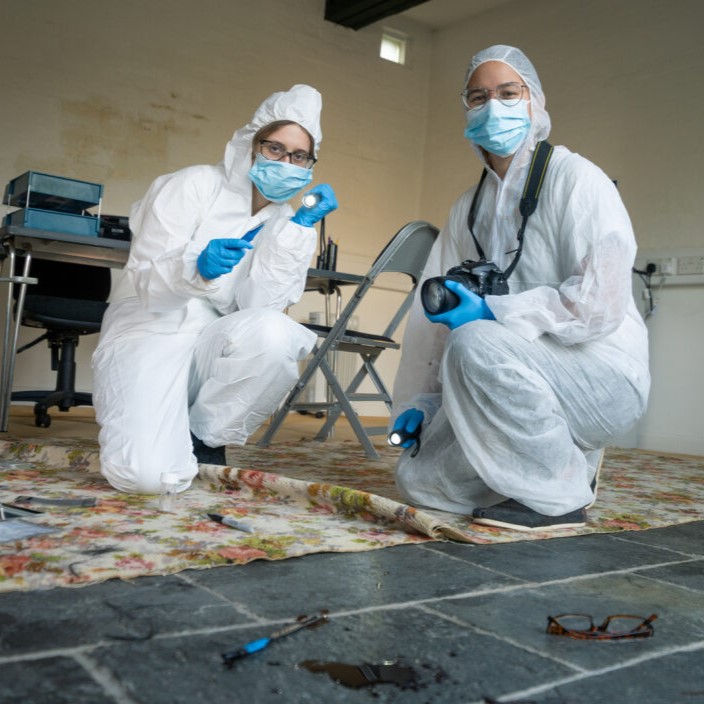 Forensics department academics in white suits