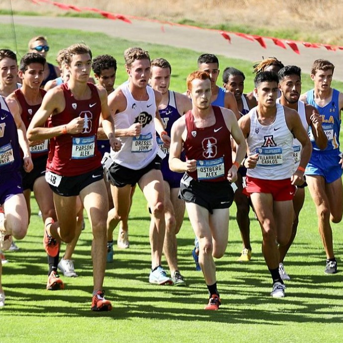 Five muddy cross country runners pose for photo after race