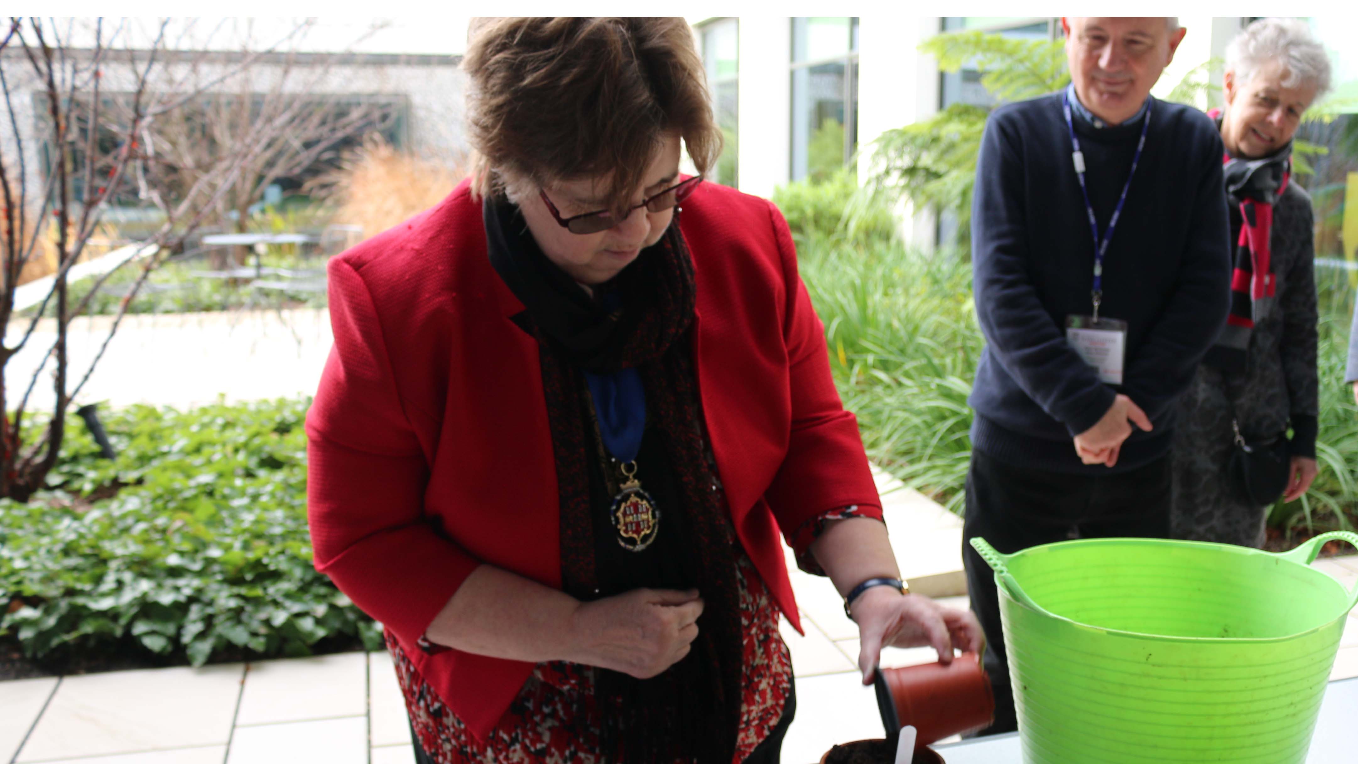 Mayor putting soil into a plant pot