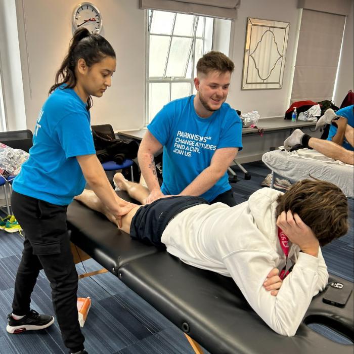 Line up of four physios in blue t-shirts