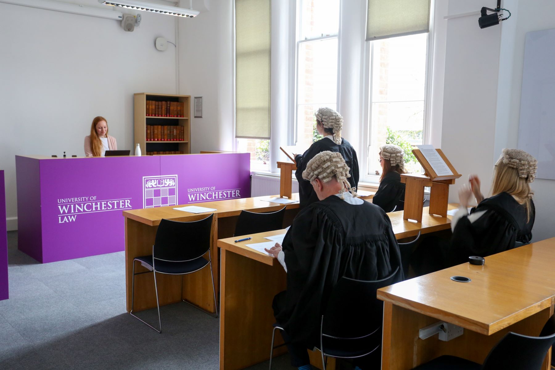 A mock trial in a court room with people in legal wigs and gowns