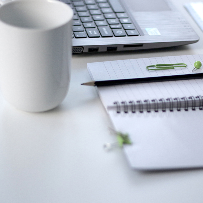 Desktop with mug, laptop notebook and pen