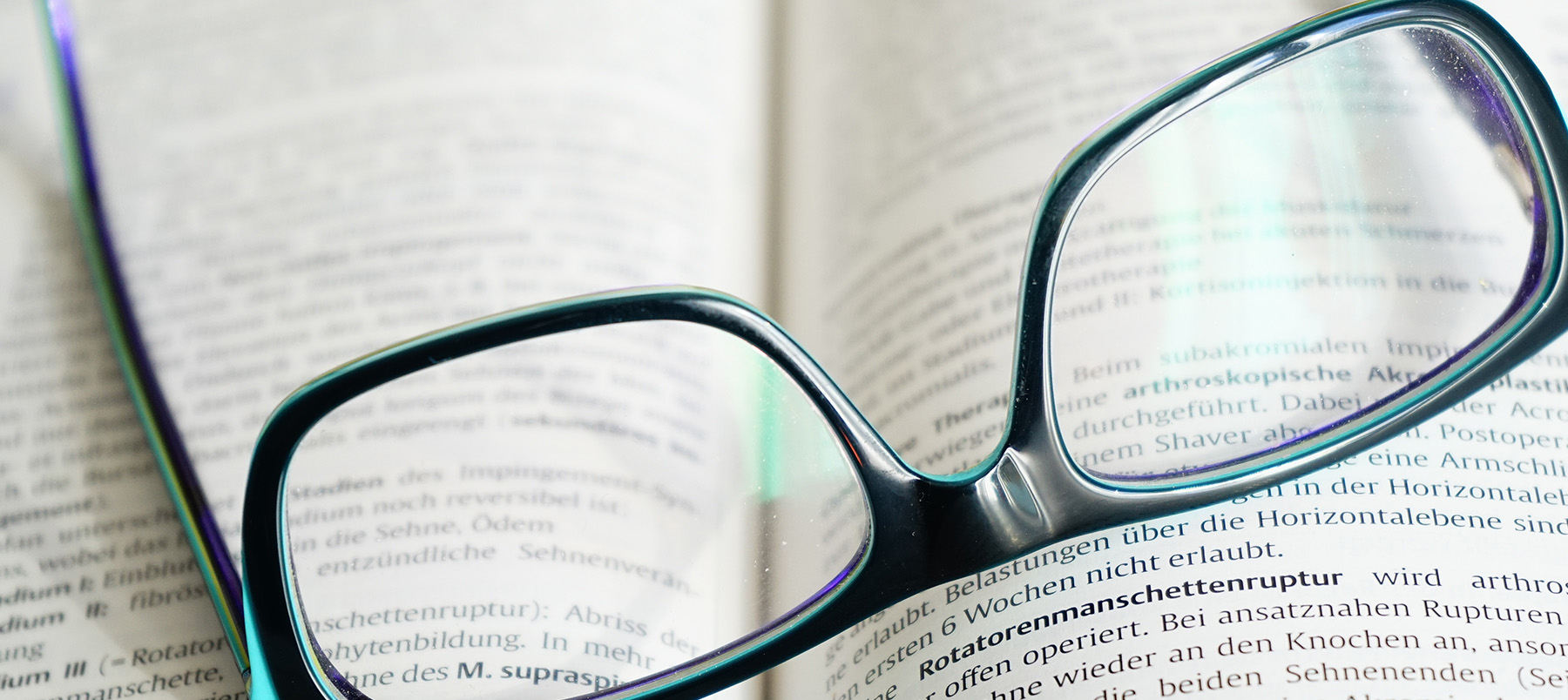 Black spectacles placed on open book