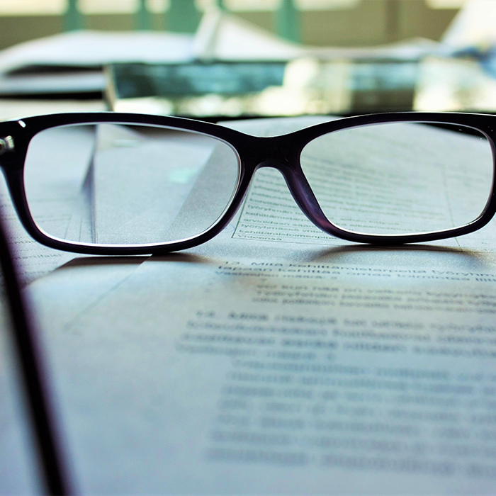 Black spectacles placed on open book