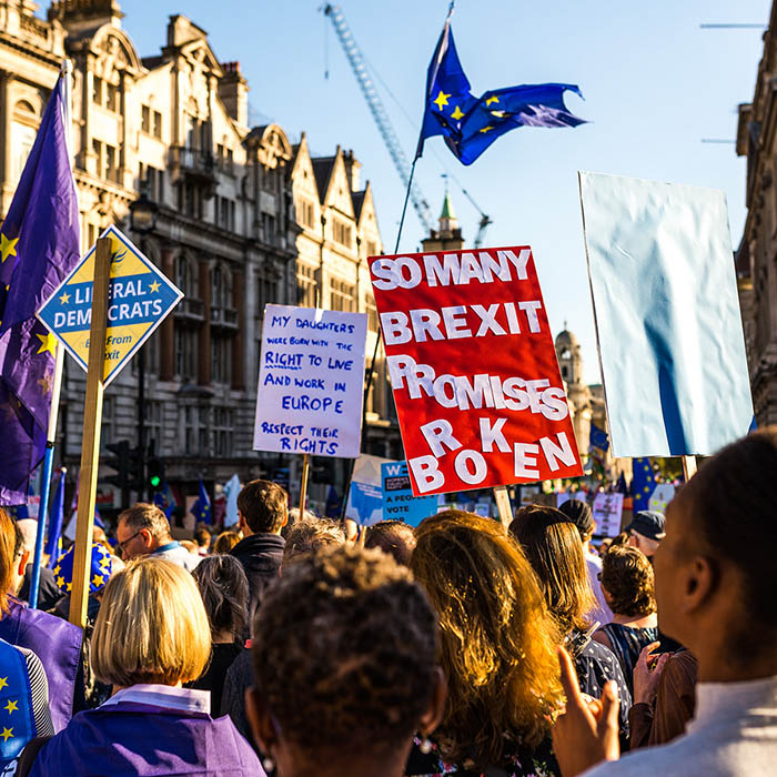 Brexit protesters marching with signs held above them reading 