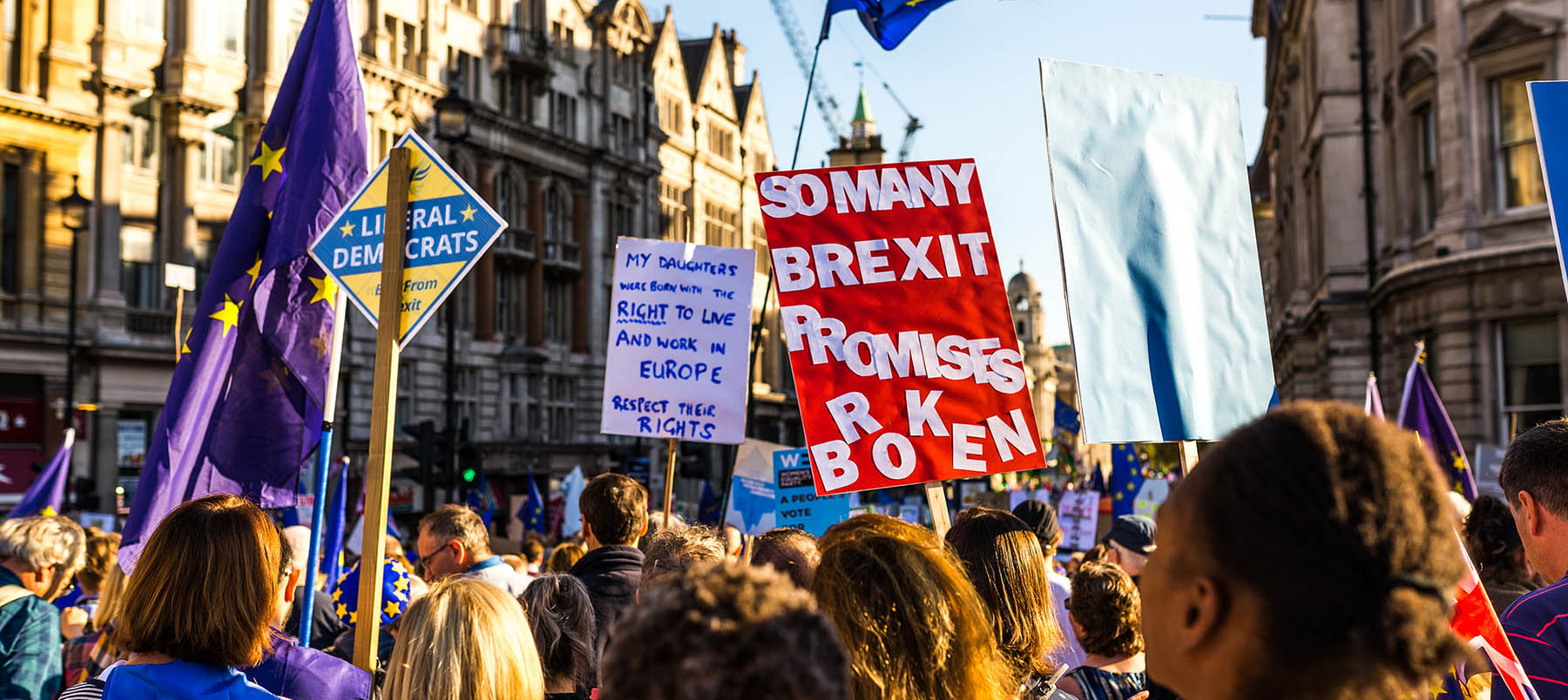 Brexit protesters marching with signs held above them reading 