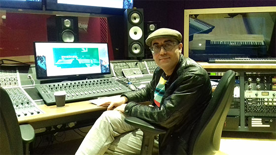 Emre Ramazanoglu smiling, seated at sound desk