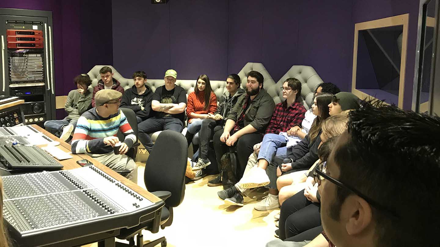 Students seated in sound booth listening to Emre Ramazanoglu