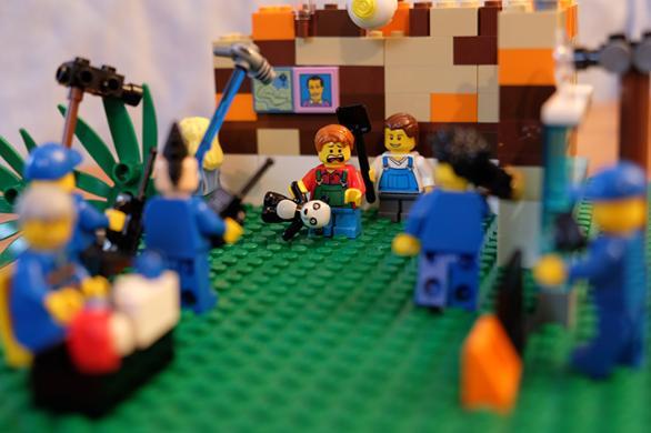 Lego display of child figure with teddy surrounded by cameras and film crew