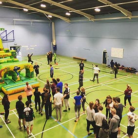 Students climb through inflatable obstacle course in sports hall