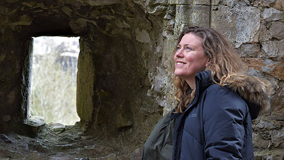 Dr Katherine Weikert standing in front of ancient city walls