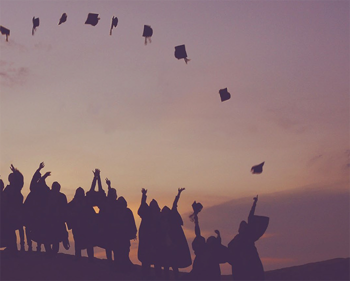 Students throwing mortar boards in the air