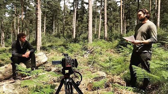 Shaun Sleighmaker in forest with photographer for Rising Forests photoshoot