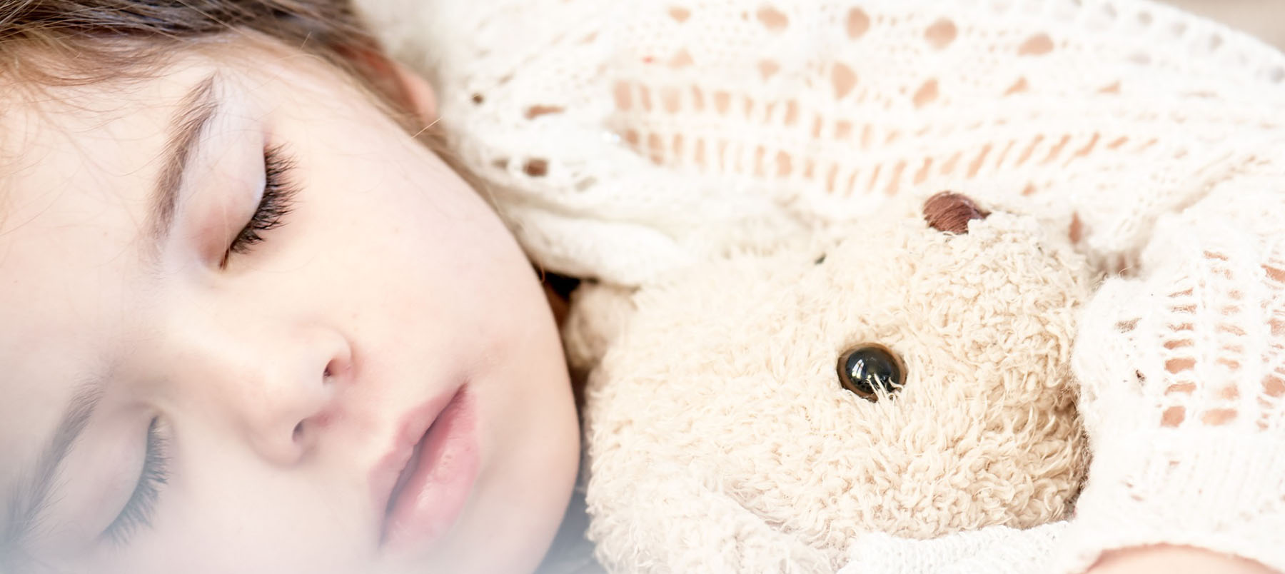 Child asleep with teddy bear 