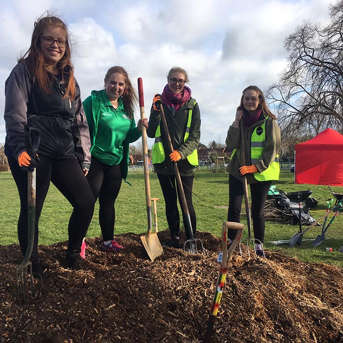 Student volunteers with gardening tools